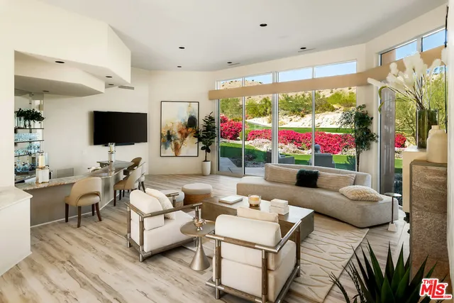 a living room with patio furniture and a large window