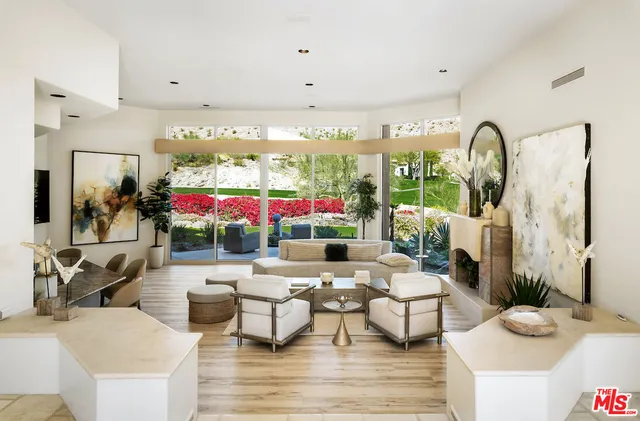 a living room with furniture a fireplace and a large window