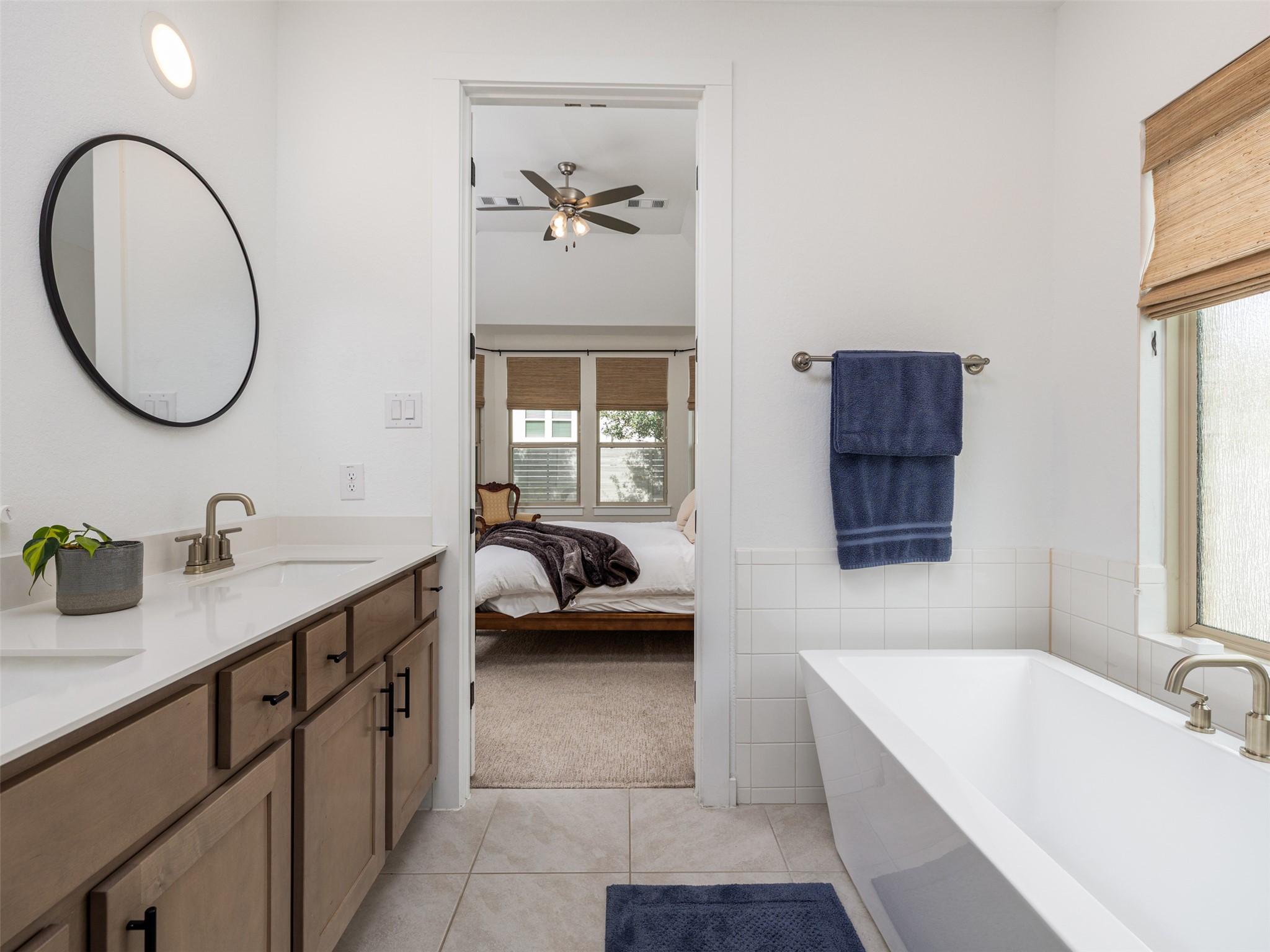 233 Arrowhead Mound Road Georgetown, TX 78628 - Photo 12 of 40 Bathroom with double vanity, a bathtub, light tile patterned flooring, connected bathroom, and tile walls
