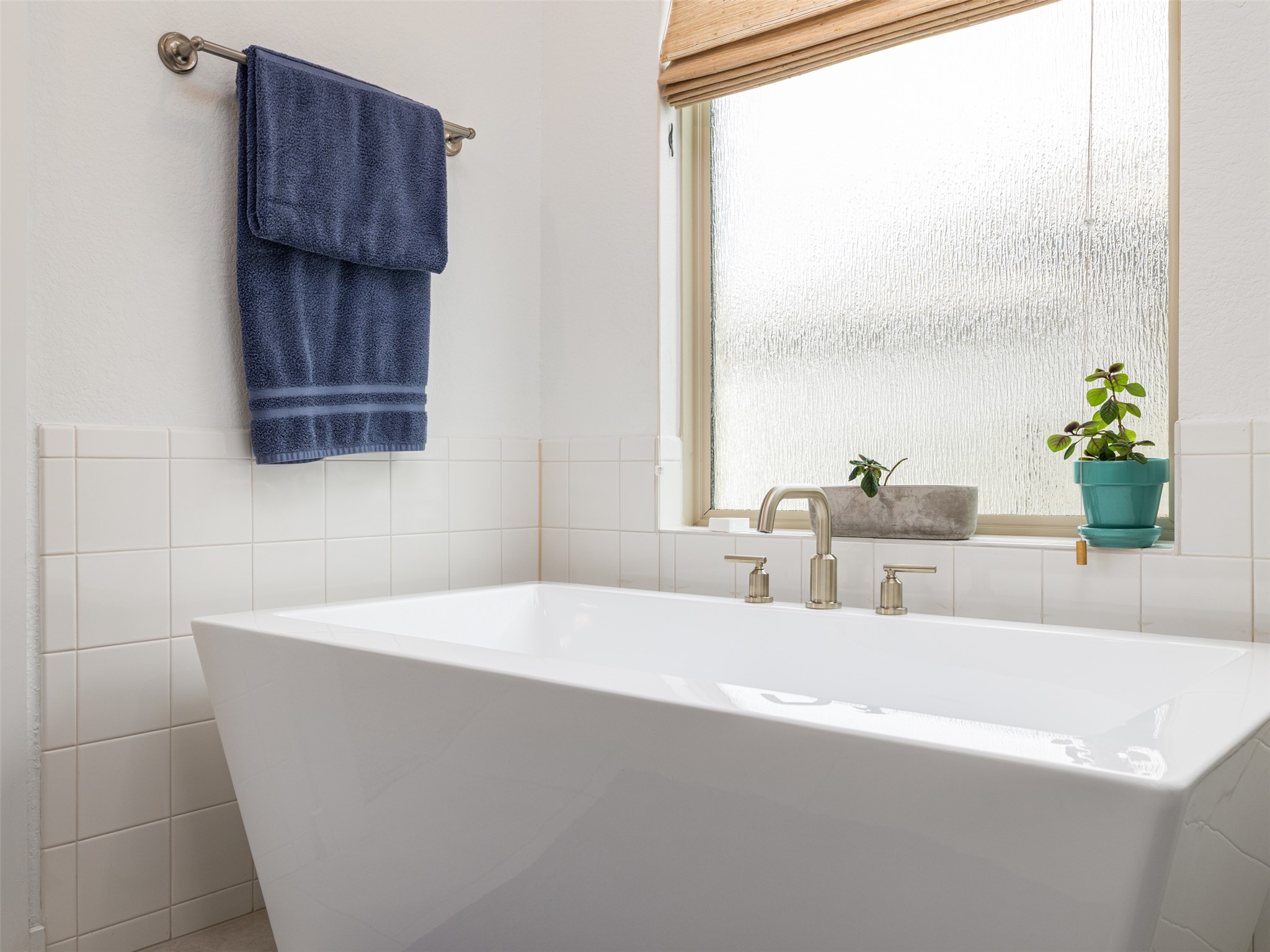 233 Arrowhead Mound Road Georgetown, TX 78628 - Photo 13 of 40 Bathroom featuring tile walls, a freestanding tub, and wainscoting