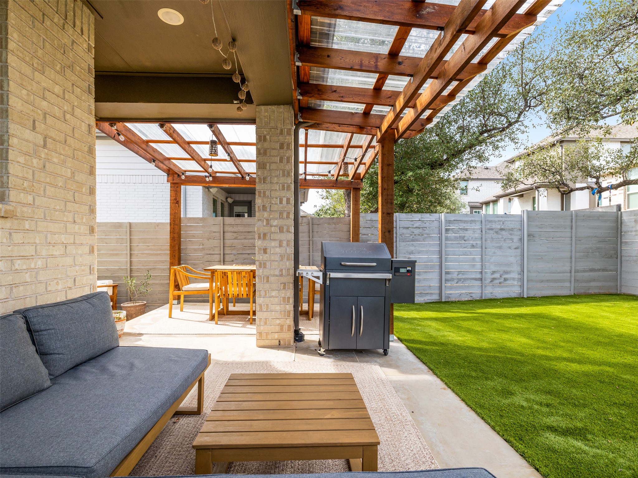 233 Arrowhead Mound Road Georgetown, TX 78628 - Photo 29 of 40 Fenced backyard with a patio, grilling area, a pergola, and an outdoor lounge area