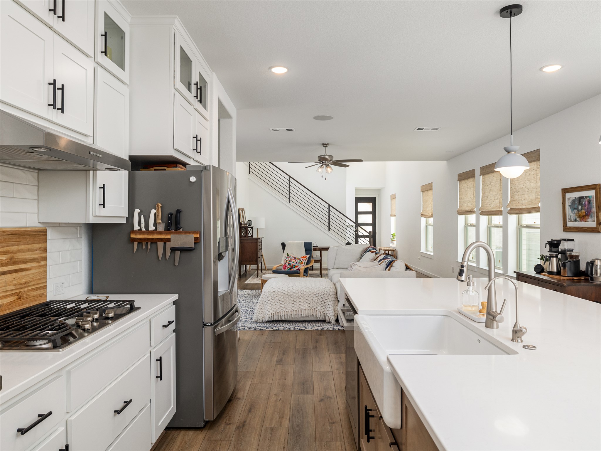 233 Arrowhead Mound Road Georgetown, TX 78628 - Photo 40 of 40 Kitchen featuring open floor plan, dark wood finished floors, stainless steel appliances, decorative light fixtures, and white cabinetry