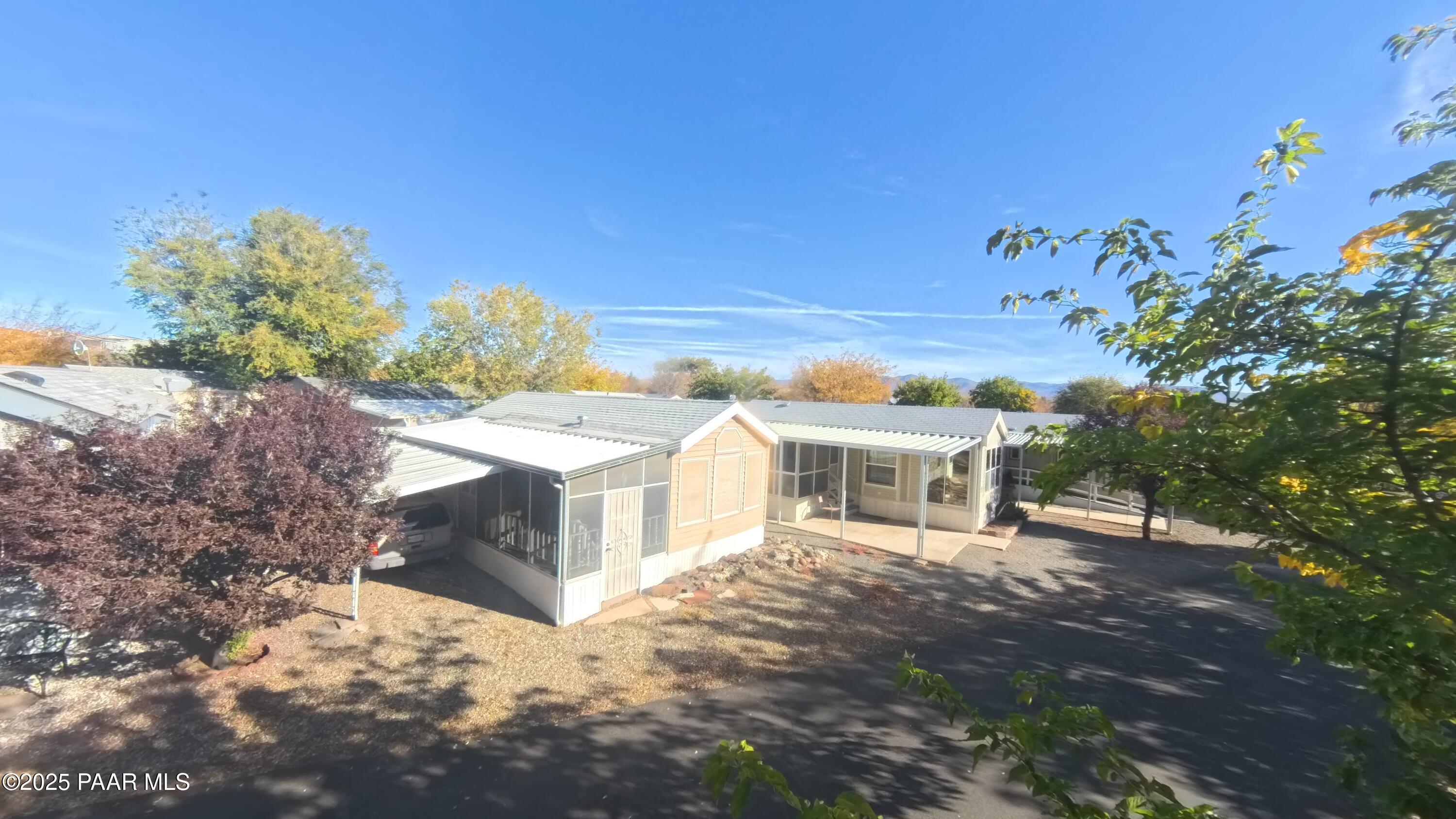 11250 East State Rte 69, Unit 61 Prescott Valley, AZ 86314 - Photo 24 of 41 a view of a white house with a yard and sitting area