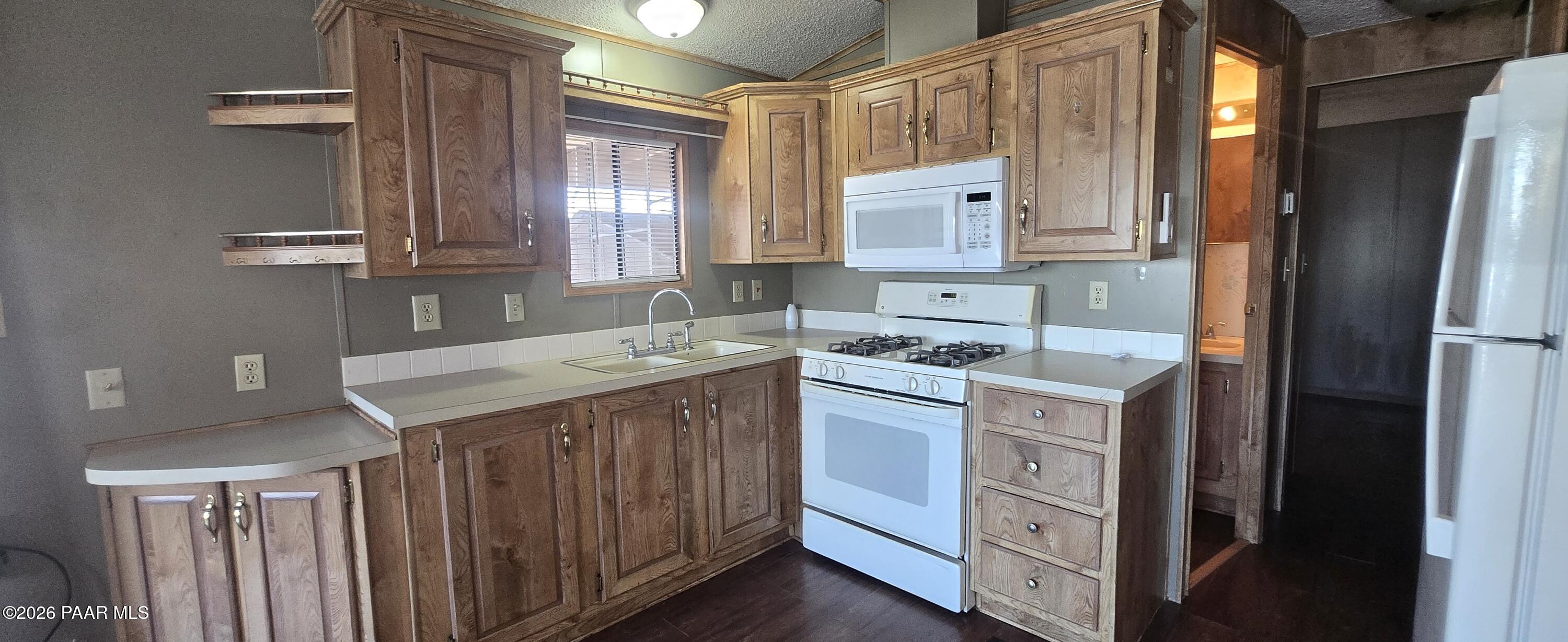 11250 East State Rte 69, Unit 61 Prescott Valley, AZ 86314 - Photo 9 of 41 a kitchen with a sink stove and cabinets