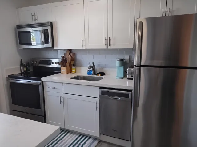 a kitchen with a refrigerator sink and cabinets