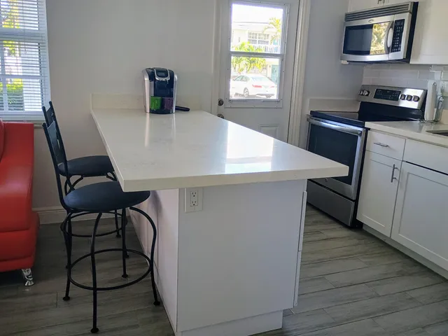 a kitchen with stainless steel appliances a stove a microwave a sink and cabinets