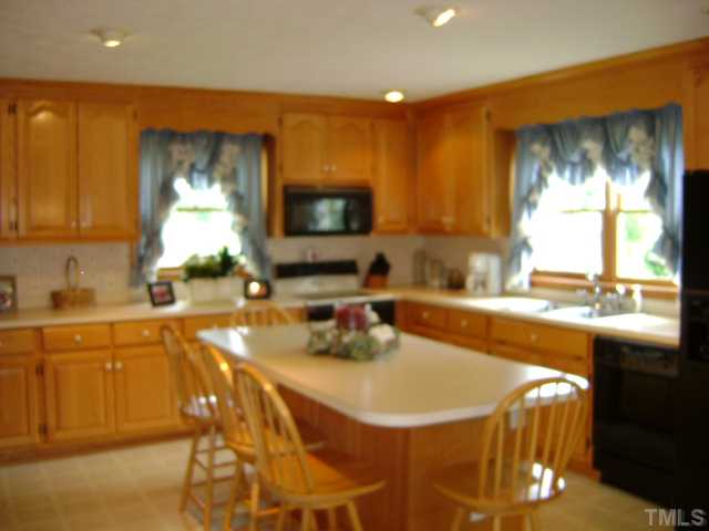 1100 Tatum Road Roxboro, NC 27574 - Photo 4 of 10 a kitchen with stainless steel appliances a sink a stove a microwave a sink and cabinets