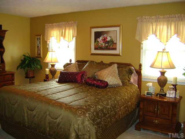 1100 Tatum Road Roxboro, NC 27574 - Photo 5 of 10 a bedroom with a bed and a chandelier