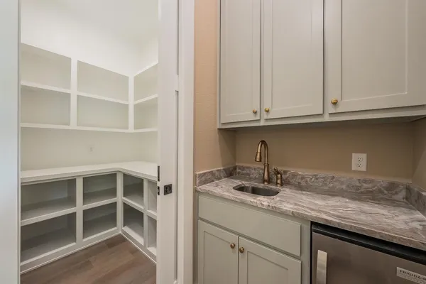 a bathroom with a granite countertop double vanity sink and mirror