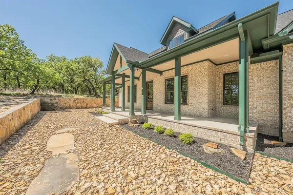 an empty room with wooden floor fireplace and windows