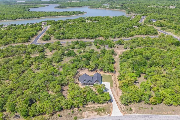 an empty room with wooden floor fireplace and windows