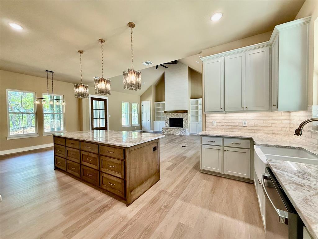 114 Ridgeline Drive Chico, TX 76431 - Photo 8 of 23 a large kitchen with kitchen island a large counter space a sink stainless steel appliances and cabinets