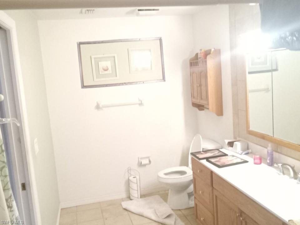 8213 Albatross Road Fort Myers, FL 33967 - Photo 11 of 17 a bathroom with a toilet sink and mirror