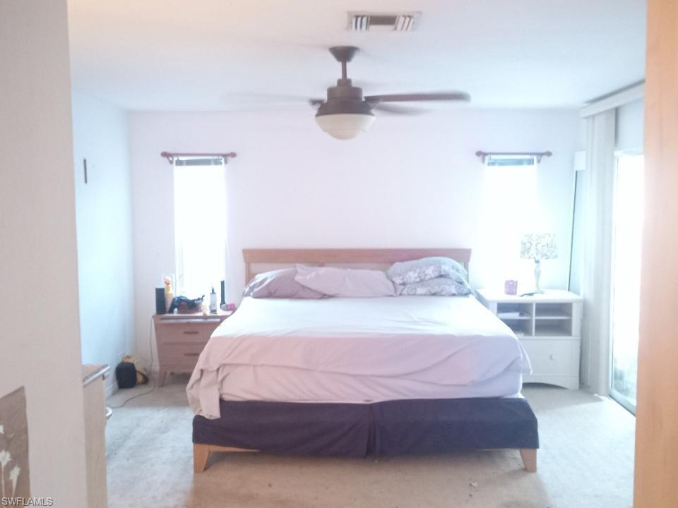 8213 Albatross Road Fort Myers, FL 33967 - Photo 13 of 17 a bedroom with a bed and a chandelier