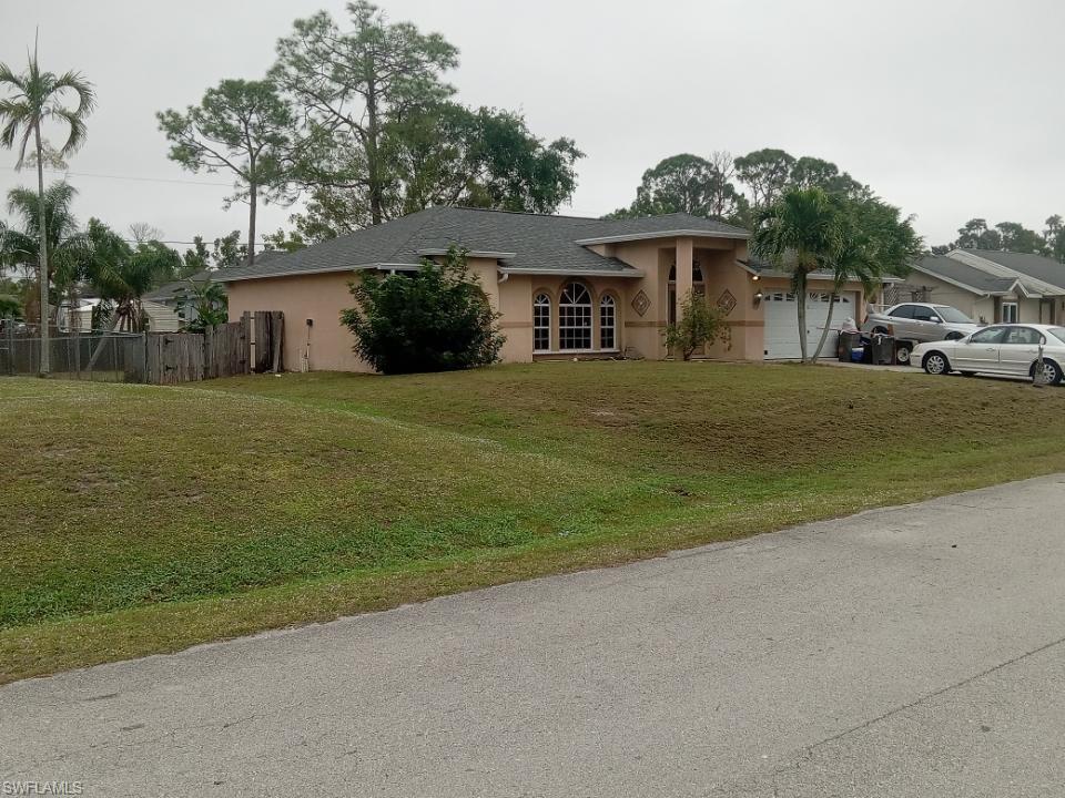 8213 Albatross Road Fort Myers, FL 33967 - Photo 3 of 17 a front view of a house with a garden
