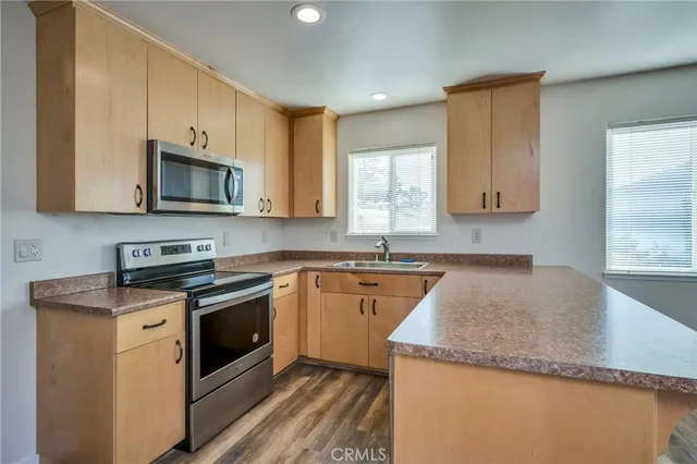 a kitchen with stainless steel appliances granite countertop a stove a sink and a microwave