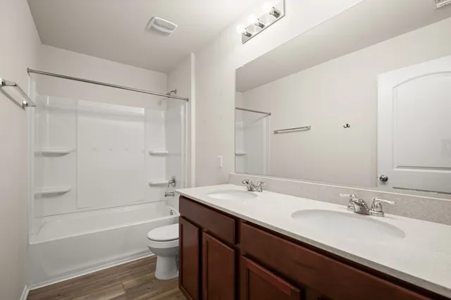 a bathroom with a granite countertop sink toilet a shower and a bathtub
