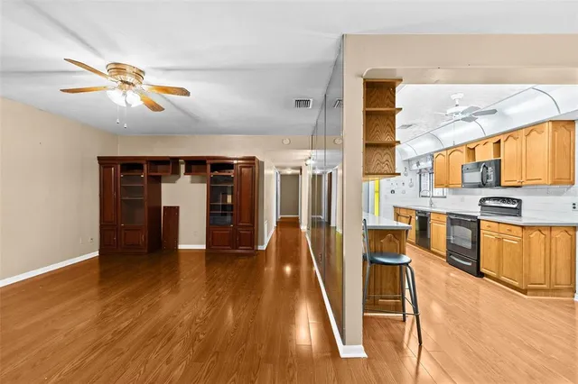 a view of a hallway with wooden floor and stairs