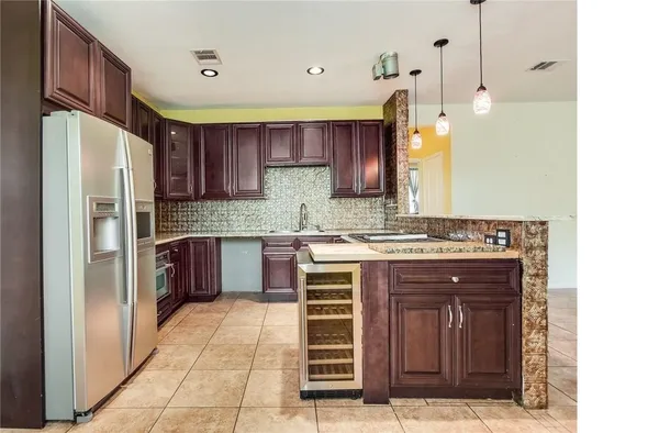 a kitchen with a refrigerator sink and cabinets
