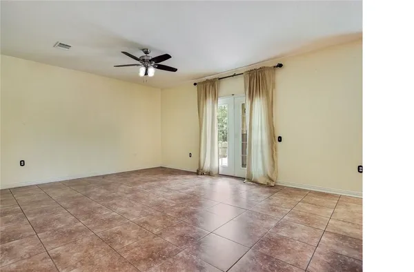 a view of a livingroom with a ceiling fan & entryway