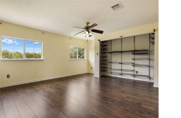 a view of a room with wooden floor closet and windows