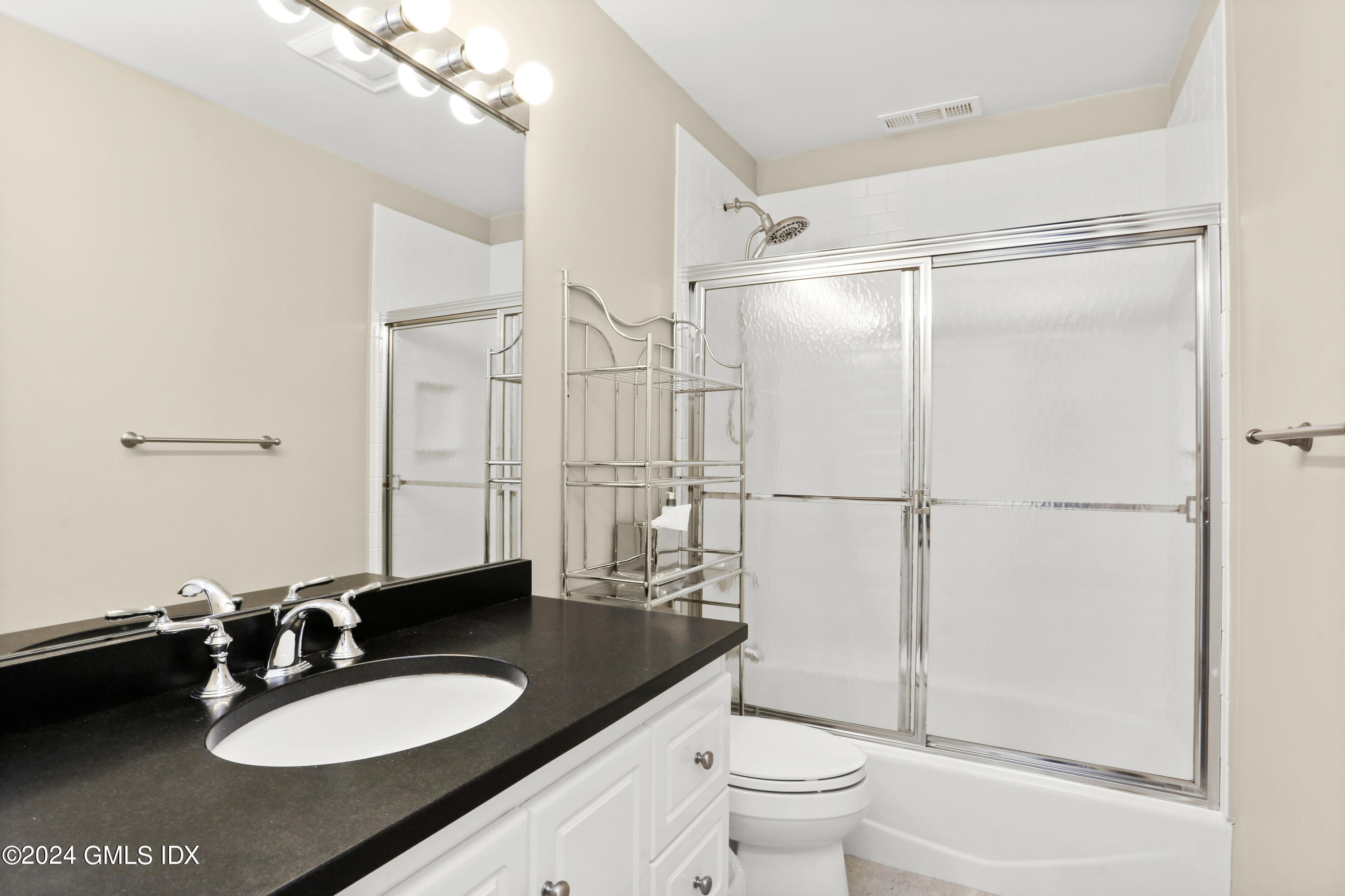 186 Field Point Road, Unit 6A Greenwich, CT 06830 - Photo 16 of 32 a bathroom with a sink toilet a mirror and shower