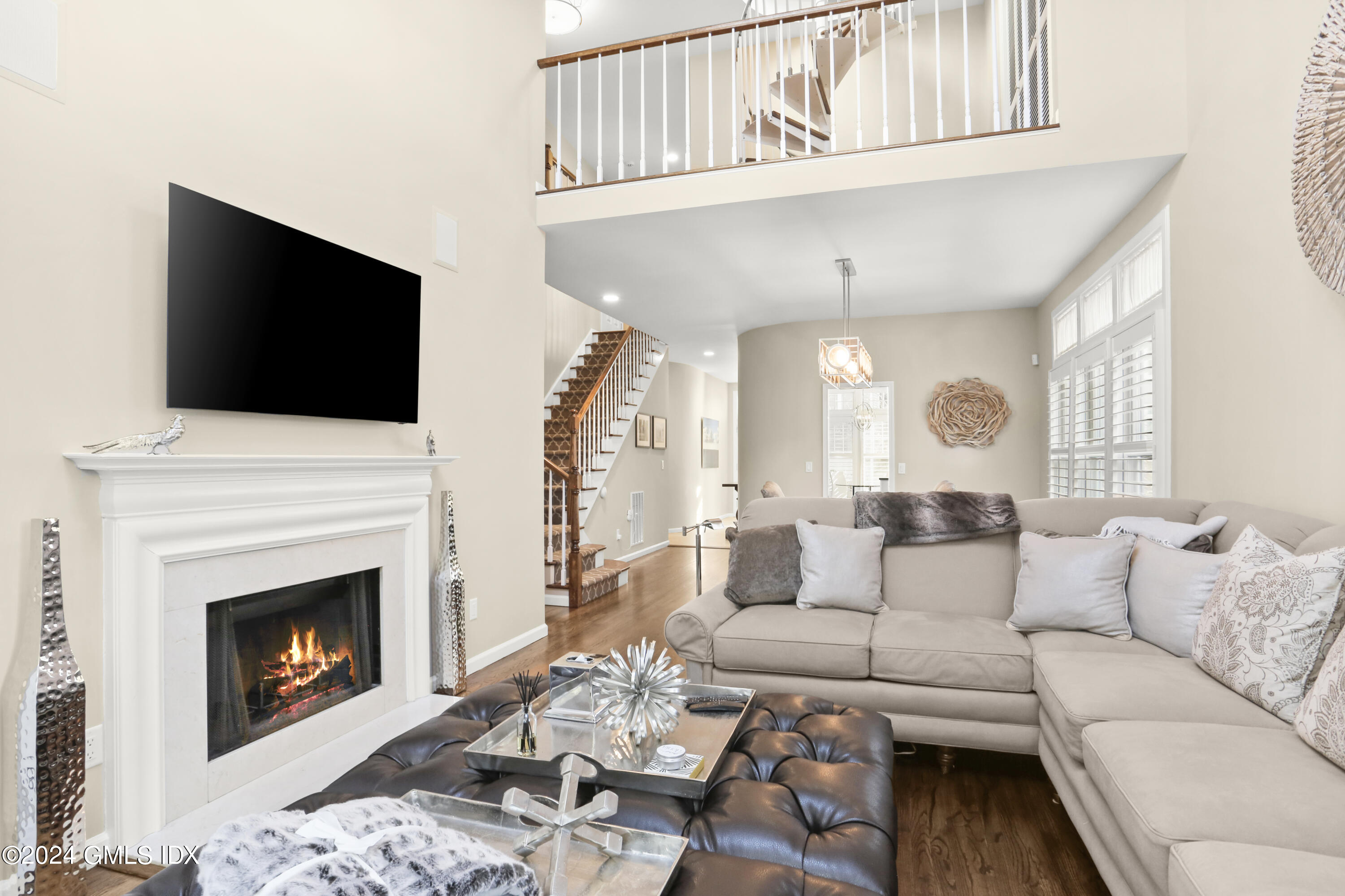 186 Field Point Road, Unit 6A Greenwich, CT 06830 - Photo 5 of 32 a living room with furniture a fireplace and a flat screen tv