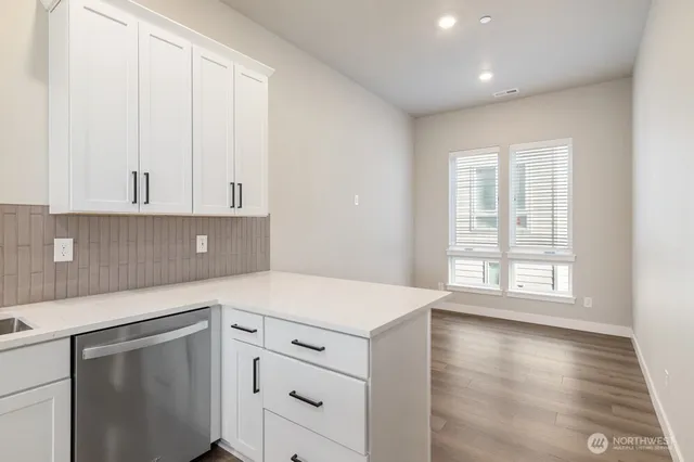 a kitchen with white cabinets and a window
