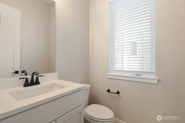 a bathroom with a sink a toilet and a window