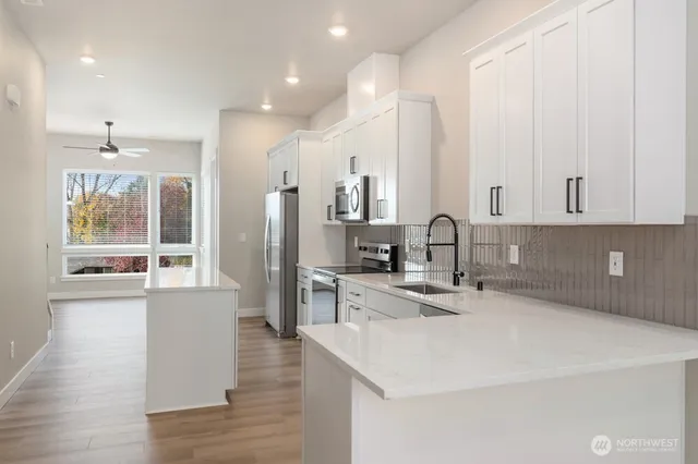 a kitchen with stainless steel appliances a sink stove and cabinets