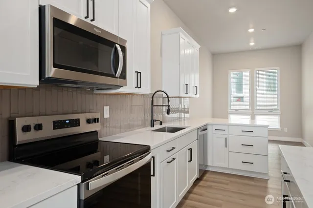 a kitchen with a sink stove and microwave