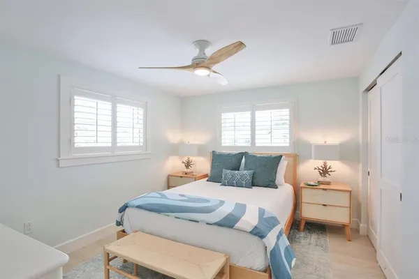 a bedroom with a bed and a mirror on dresser