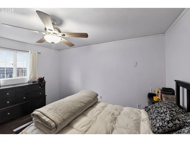 a bedroom with a bed and a chandelier fan