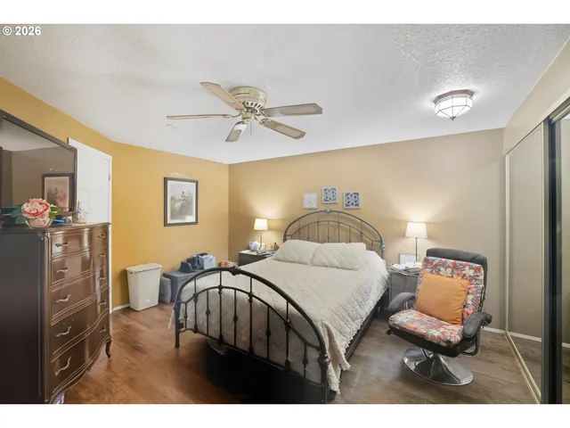 a bedroom with a bed and a lamp on dresser