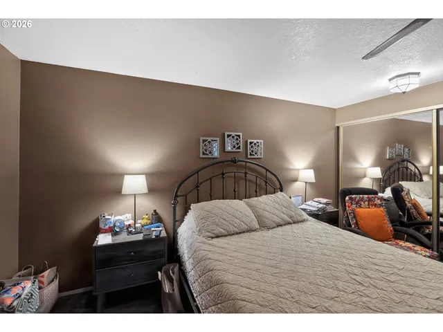 a bedroom with a bed a mirror and lamp on desk