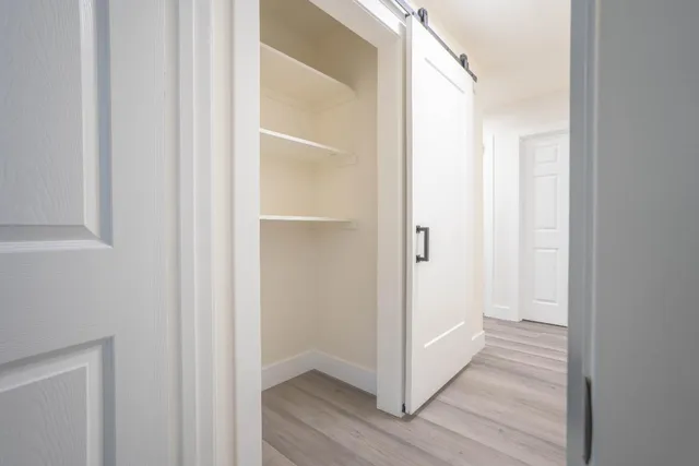 a view of a hallway with wooden floor