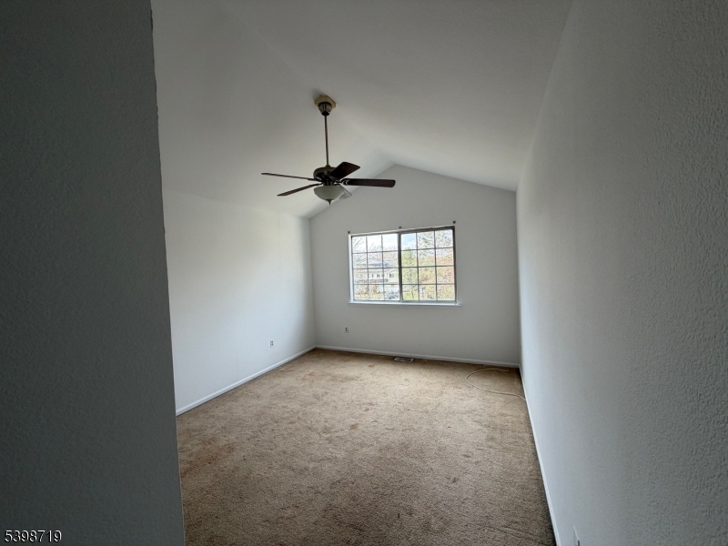 94 Wescott Road Bedminster, NJ 07921 - Photo 11 of 17 en empty room with windows and chandelier fan