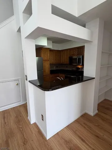 a room with wooden floor and white cabinets