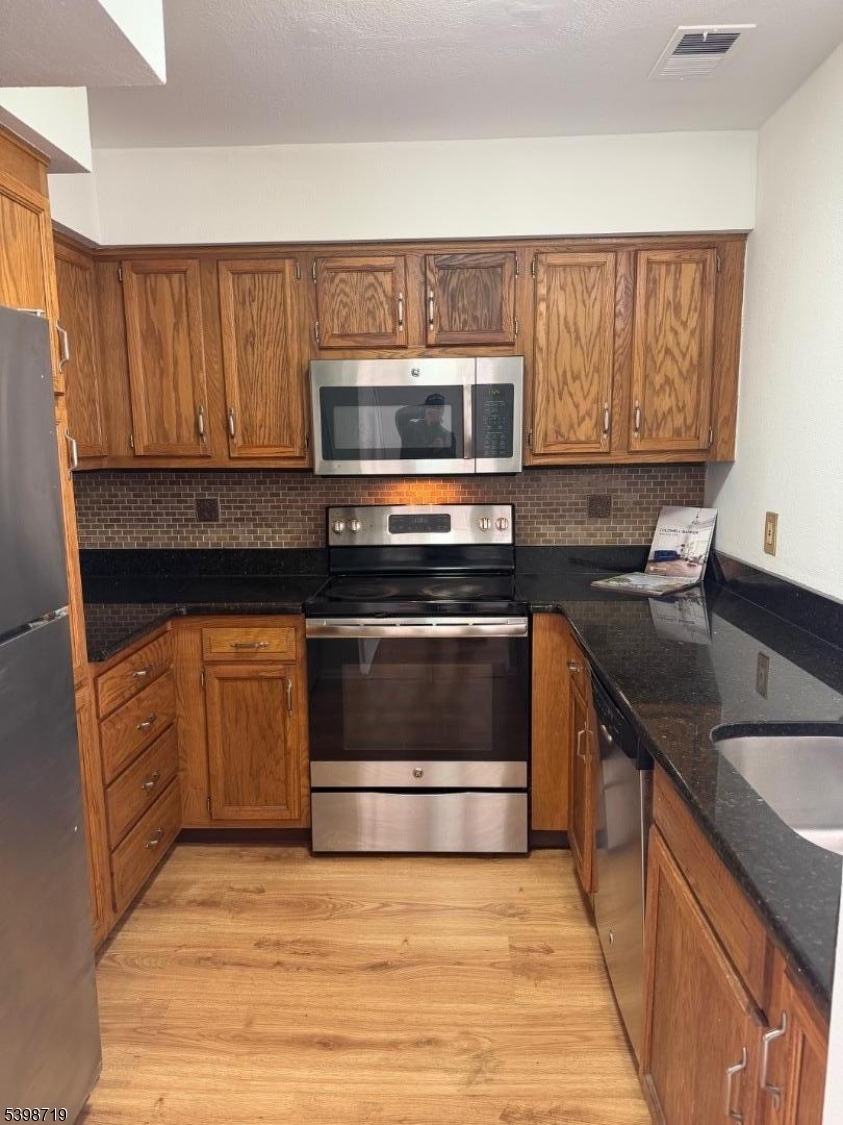 94 Wescott Road Bedminster, NJ 07921 - Photo 6 of 17 a kitchen with granite countertop wood cabinets stainless steel appliances and a sink