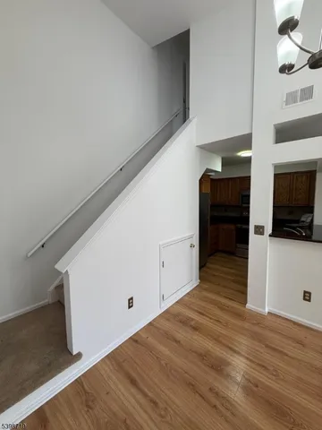 a view of a kitchen with wooden floor and cabinets