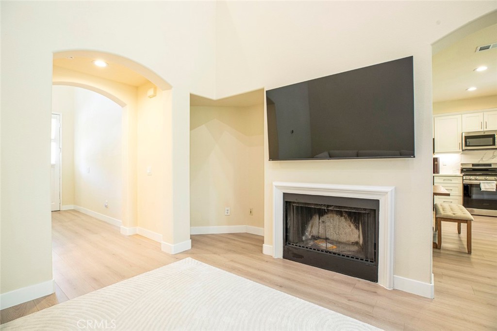 23301 Montecito Place Valencia, CA 91354 - Photo 10 of 45 a living room with a fireplace and a flat screen tv