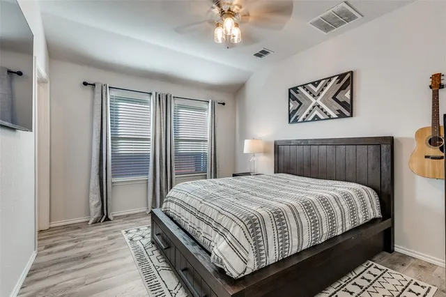 a bedroom with a large bed and a chandelier