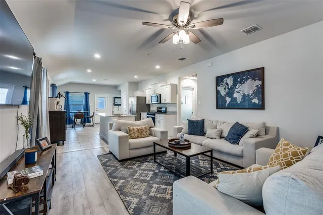 a living room with furniture kitchen view and a chandelier