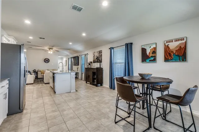 a living room with furniture a refrigerator and kitchen view