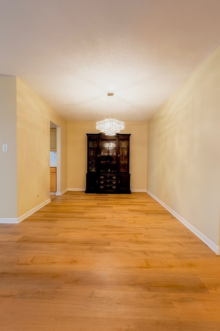 36 West Fern Court, Unit 117B Palatine, IL 60067 - Photo 3 of 11 a big room with wooden floor and a ceiling fan