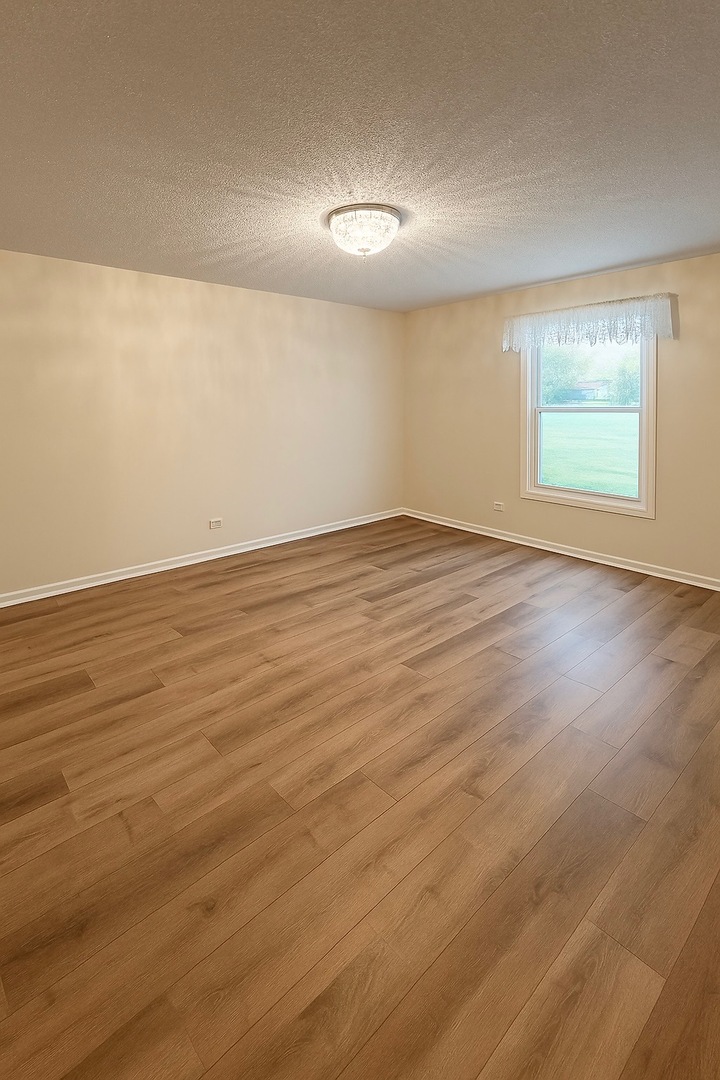 36 West Fern Court, Unit 117B Palatine, IL 60067 - Photo 5 of 11 a view of an empty room with wooden floor and a window