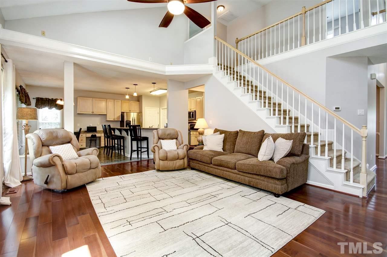 12305 Amoretto Way Raleigh, NC 27613 - Photo 12 of 30 Soaring ceilings showcase your large family room with gas fireplace and the Brazilian Cherry floors continue through. Great view of the large landscaped yard that is fenced in for privacy.