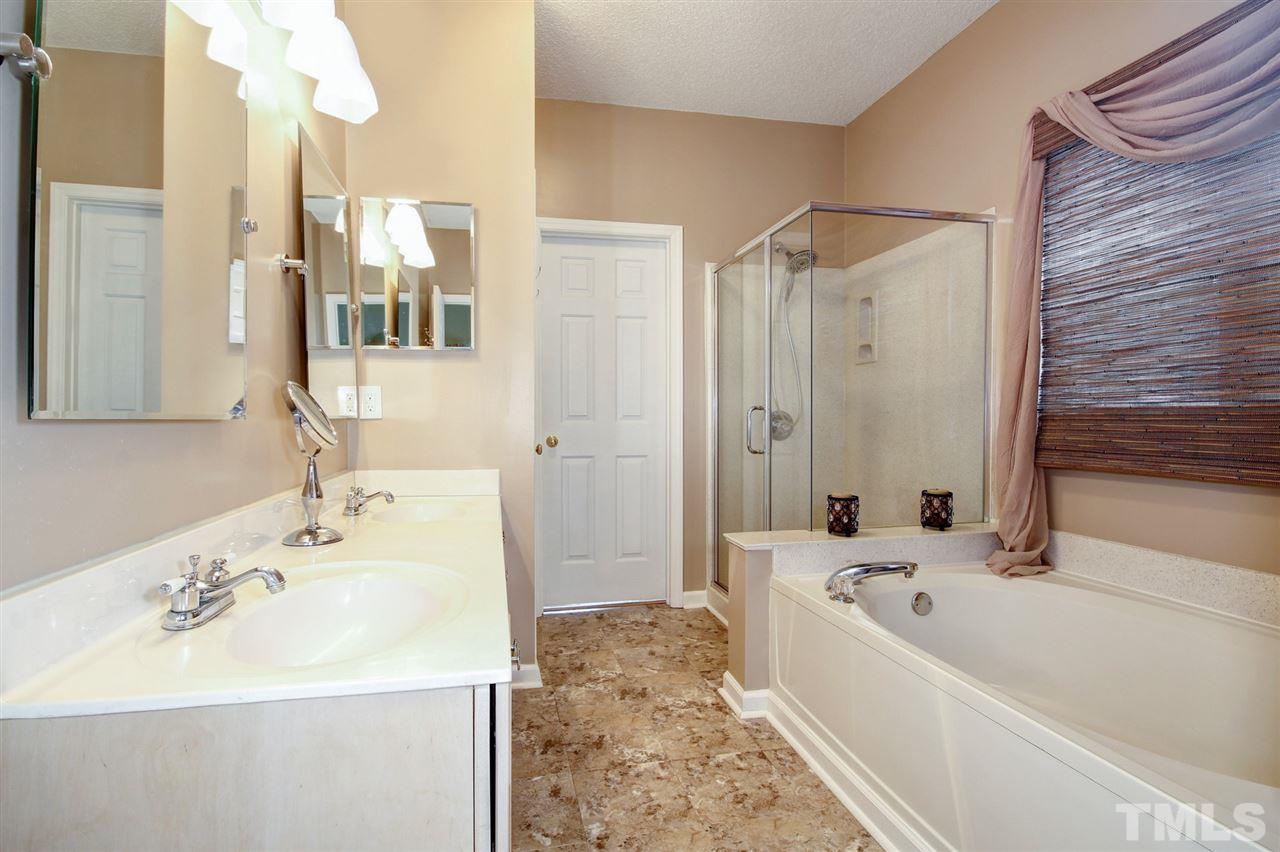 12305 Amoretto Way Raleigh, NC 27613 - Photo 17 of 30 Spa like owner's suite with dual vanity, vinyl tile flooring and garden tub.