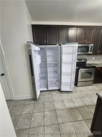 a kitchen with granite countertop a stove a microwave and a refrigerator