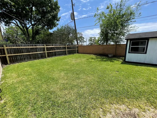 a view of a backyard with couches plants and large tree